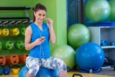 spor salonunda Smartphone kullanan kadın