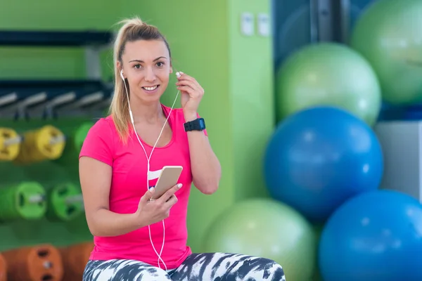 Mujer usando smartphone en el gimnasio —  Fotos de Stock