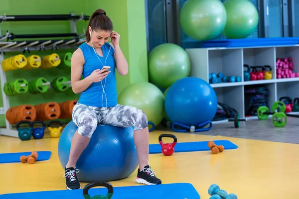 spor salonunda Smartphone kullanan kadın