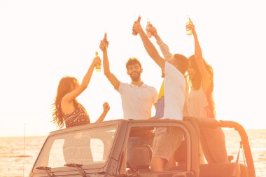 insanlar plajda arabada eğleniyor