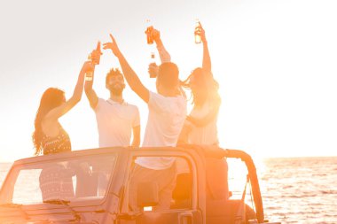 insanlar plajda arabada eğleniyor