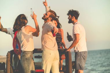 insanlar plajda arabada eğleniyor