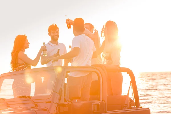 Personer som har roligt i bilen på stranden — Stockfoto