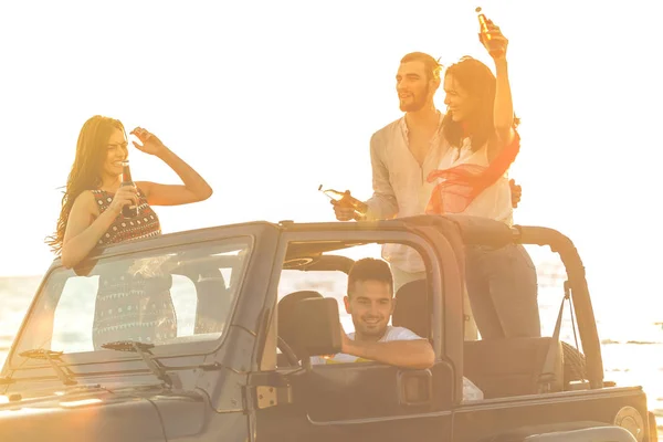 Menschen amüsieren sich im Auto am Strand — Stockfoto