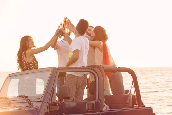 Pessoas se divertindo no carro na praia — Fotografia de Stock