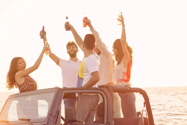 Personer som har roligt i bilen på stranden — Stockfoto