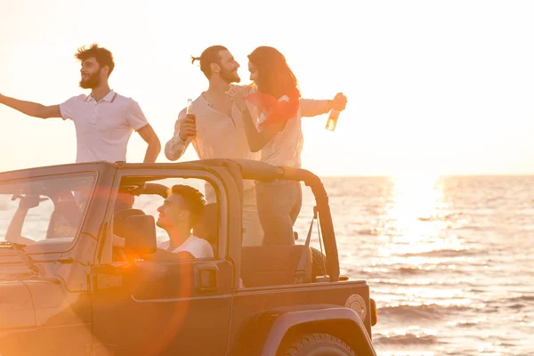 Personas que se divierten en coche en la playa — Foto de Stock