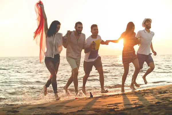 Jóvenes corriendo en la playa — Foto de Stock