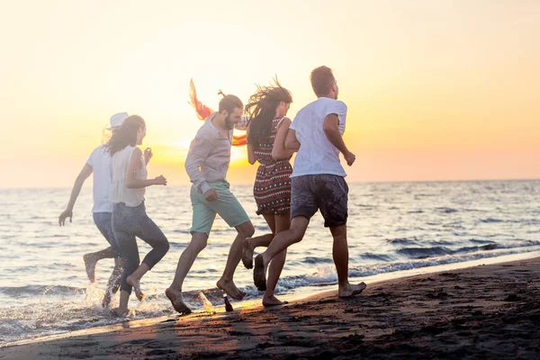 Jonge mensen lopen op strand — Stockfoto