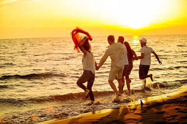 Jóvenes corriendo en la playa — Foto de Stock