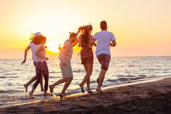 Jóvenes corriendo en la playa — Foto de Stock