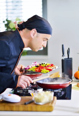 Chef malzemeler tencereye koyarak 