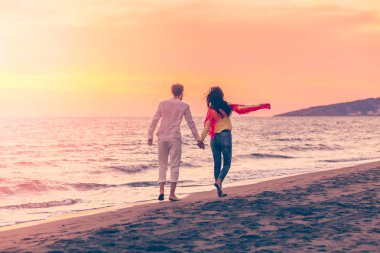 Güzel kumsalda gün batımında Çift