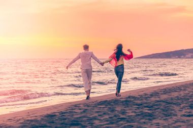 Güzel kumsalda gün batımında Çift