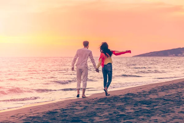 Koppel op het strand bij zonsondergang — Stockfoto