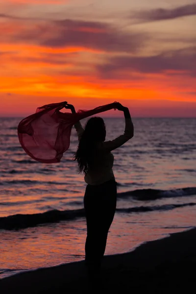 Mladá dívka chůzi proti západu slunce — Stock fotografie