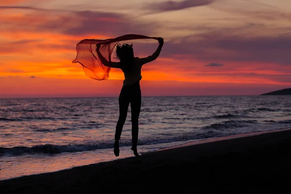 Young girl jumping against sunset — Stock Photo, Image