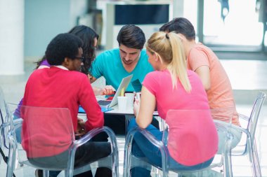 dizüstü bilgisayar kullanarak okuyan öğrenciler