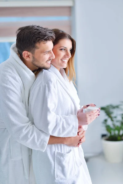 Young couple in bathrobes at kitchen — Stock Photo, Image