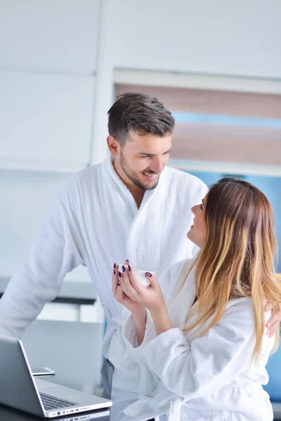 Pareja en la cocina usando un ordenador portátil — Foto de Stock