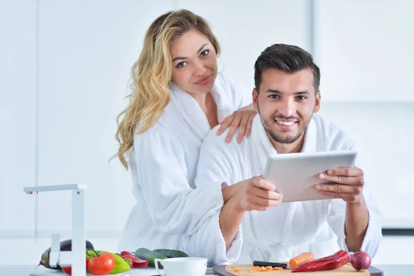 Pareja usando la tableta en la cocina — Foto de Stock