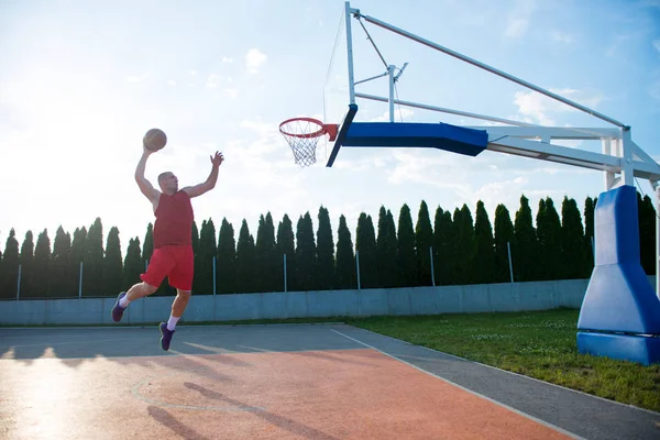 Hombre haciendo un fantástico slam dunk — Foto de Stock