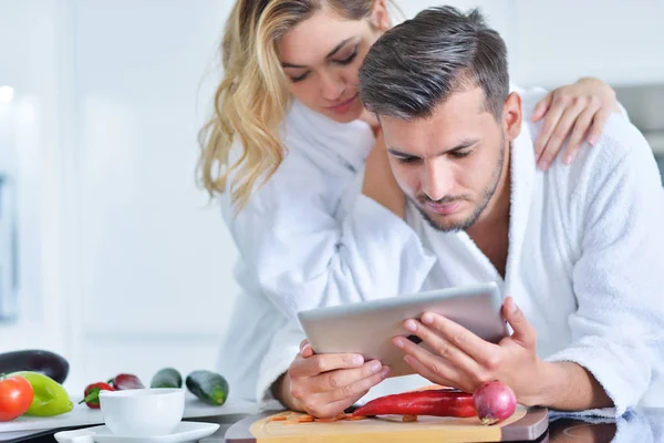 Casal usando tablet na cozinha — Fotografia de Stock