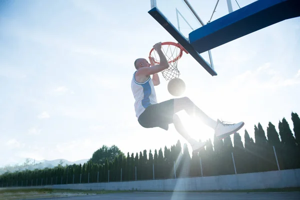 Hombre haciendo un fantástico slam dunk — Foto de Stock