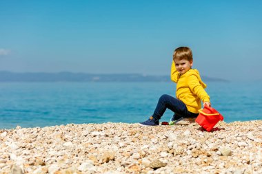 Kumsalda oynarken erkek bebek 