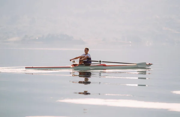 Um jovem competidor de remo no lago — Fotografia de Stock