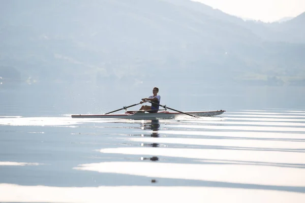 Um jovem competidor de remo no lago — Fotografia de Stock