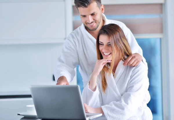 Pareja joven en albornoces en casa — Foto de Stock