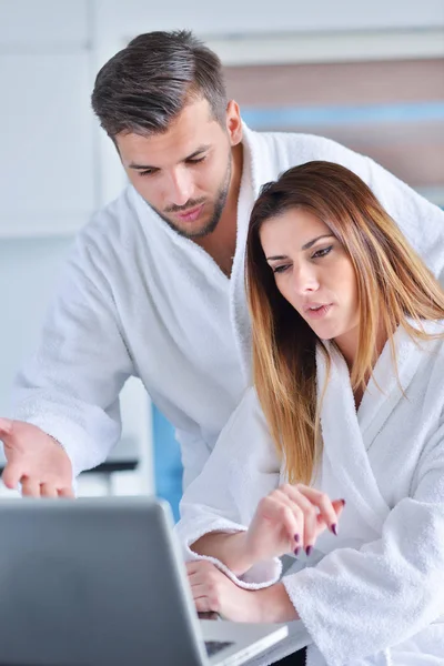 Pareja joven en albornoces en casa — Foto de Stock