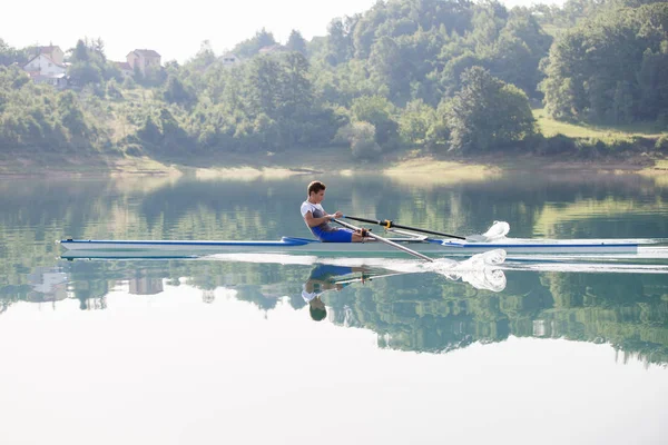 Um jovem competidor de remo no lago — Fotografia de Stock