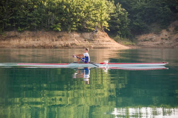 Um jovem competidor de remo no lago — Fotografia de Stock