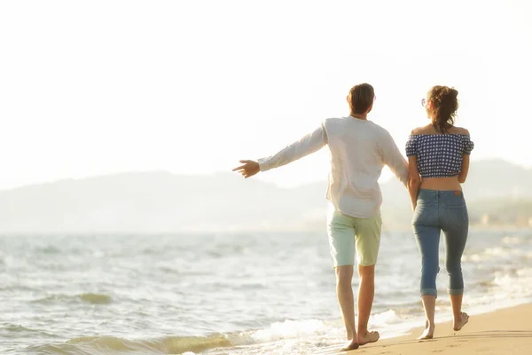 Happy couple walking on the beach — Stock Photo, Image