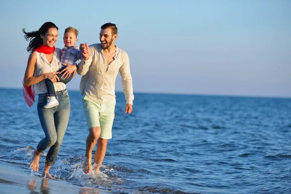 Feliz joven familia en la playa — Foto de Stock