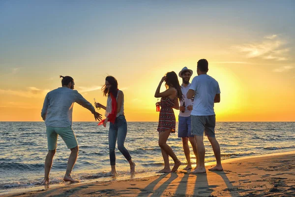 Jonge mensen dansen op het strand — Stockfoto