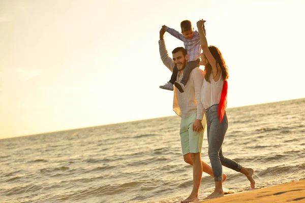 Felice giovane famiglia sulla spiaggia — Foto Stock