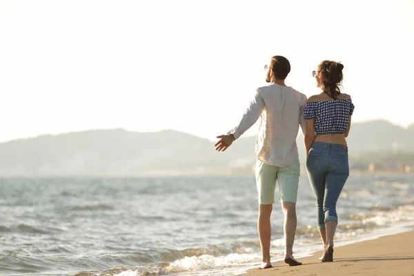 Счастливая пара прогуливаясь по пляжу — стоковое фото