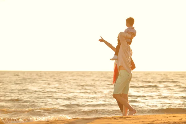 Счастливая молодая семья на пляже — стоковое фото