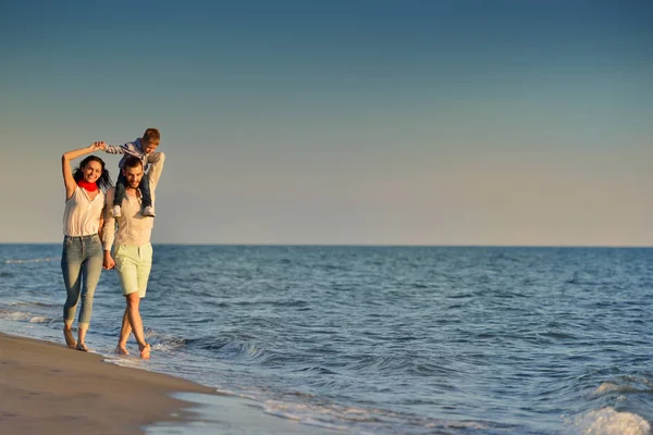 Gelukkig jong gezin op het strand — Stockfoto