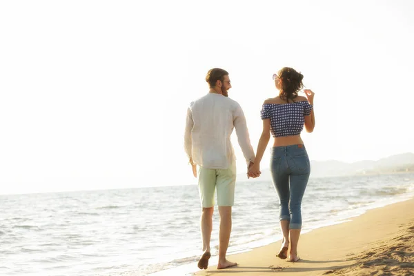 Счастливая пара прогуливаясь по пляжу — стоковое фото