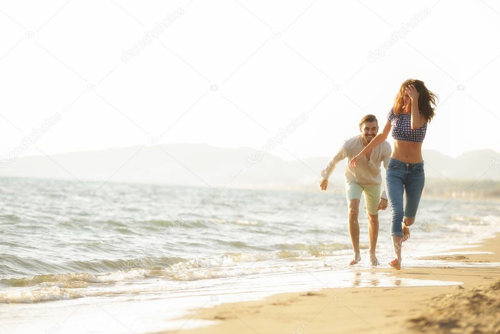 happy couple walking on the beach