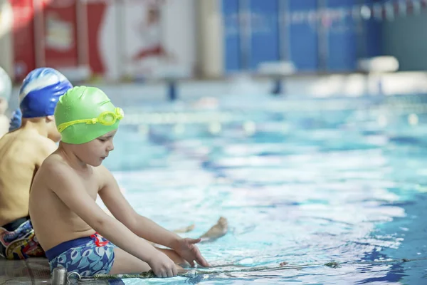 Glückliche Kindergruppe im Schwimmbad lernt schwimmen — Stockfoto