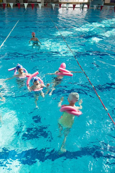 Boldog gyermekek gyerekek csoport úszástanulás medence osztály — Stock Fotó