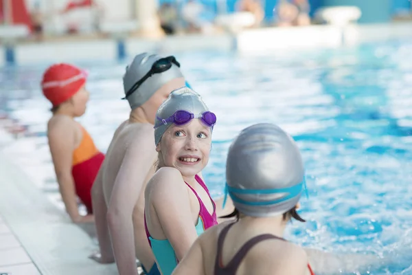 Glückliche Kindergruppe im Schwimmbad lernt schwimmen — Stockfoto