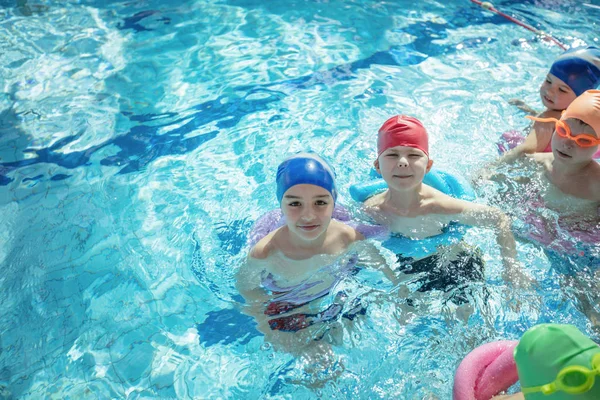 Niños felices grupo de niños en la clase de piscina aprender a nadar — Foto de Stock