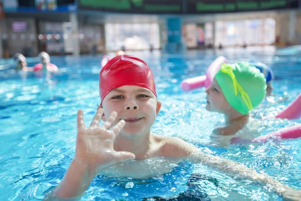 Glückliche Kindergruppe im Schwimmbad lernt schwimmen — Stockfoto