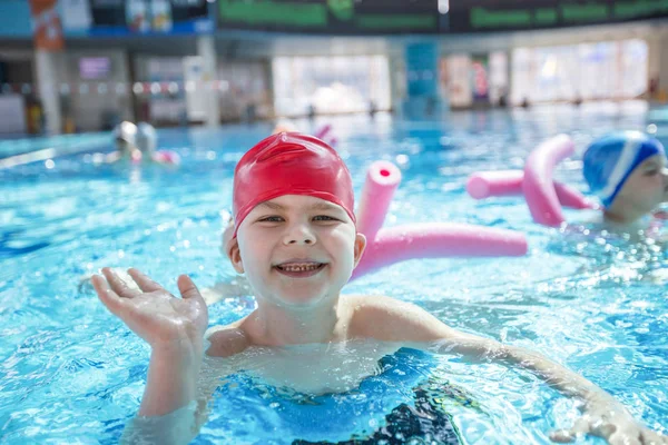 Glückliche Kindergruppe im Schwimmbad lernt schwimmen — Stockfoto